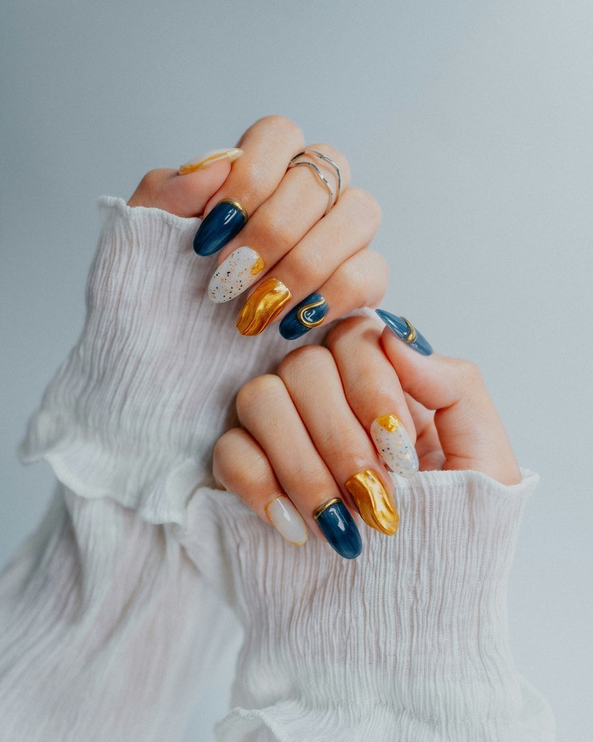 Almond-shaped nails in navy, gold and speckled white