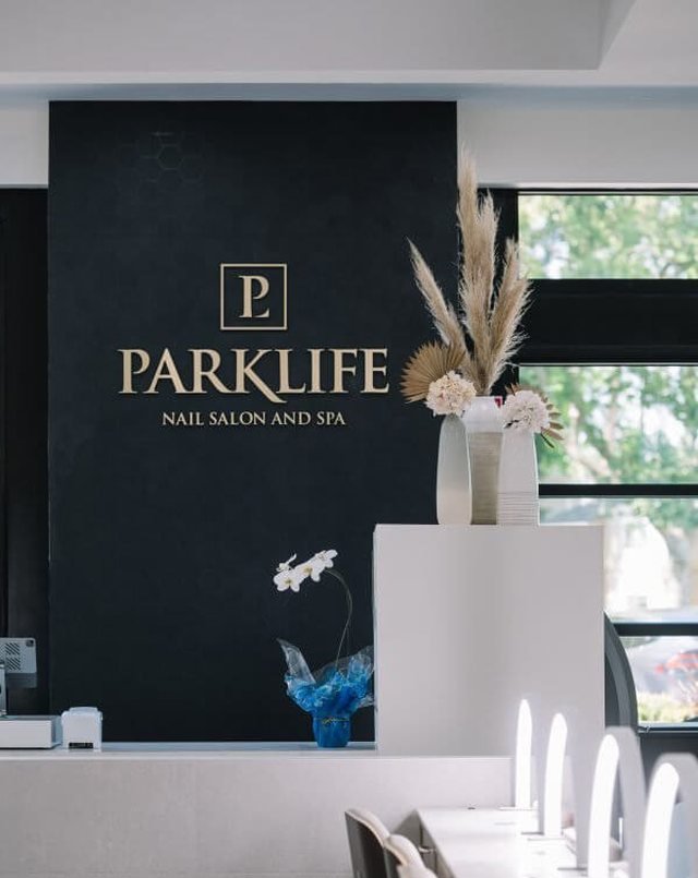 The Parklife front desk with the gold logo on a black wall